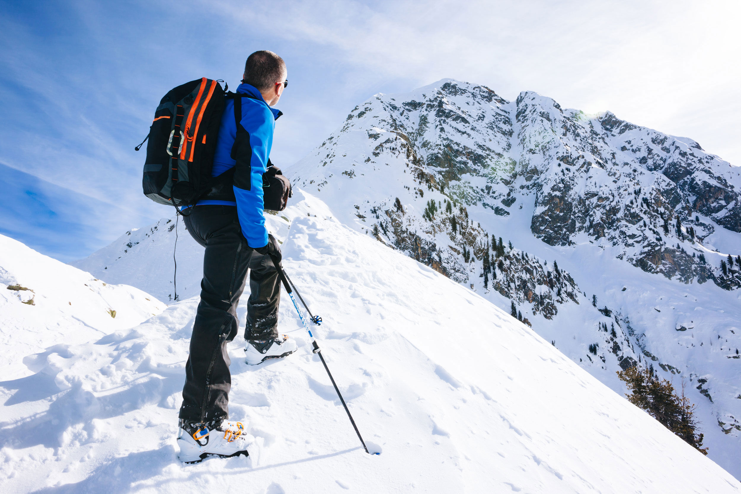 Once arrived at the summit a skier admires the nature around him.