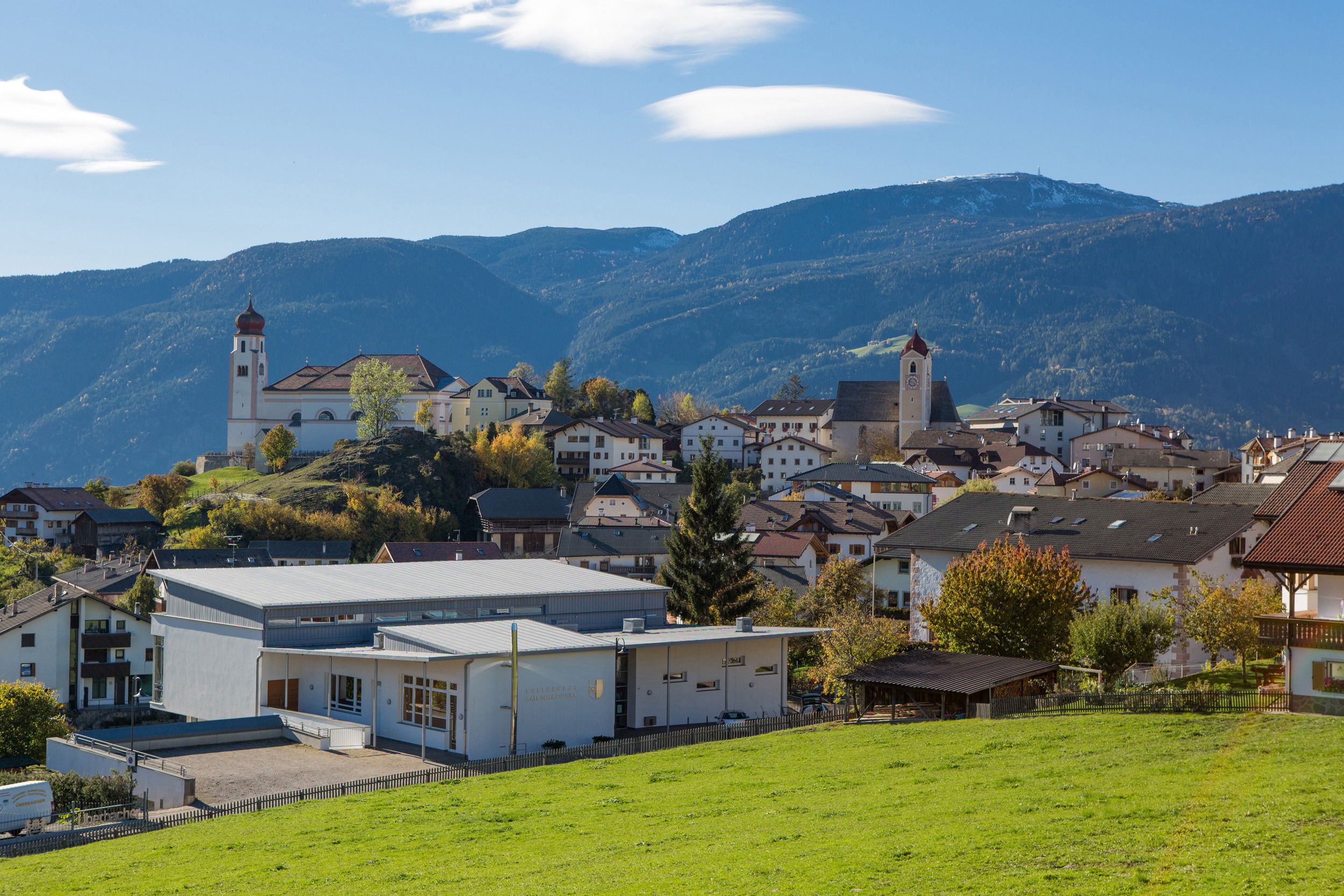 Panoramic view of a village with surrounding mountains.