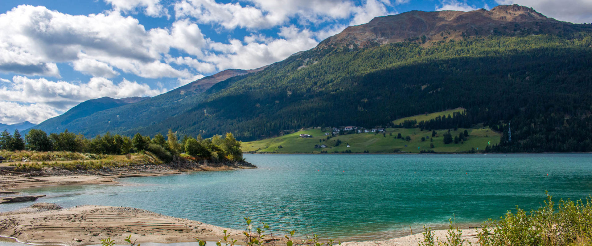 Graun on Lake Reschen A green and sandy shore of Lake Reschen near Graun.