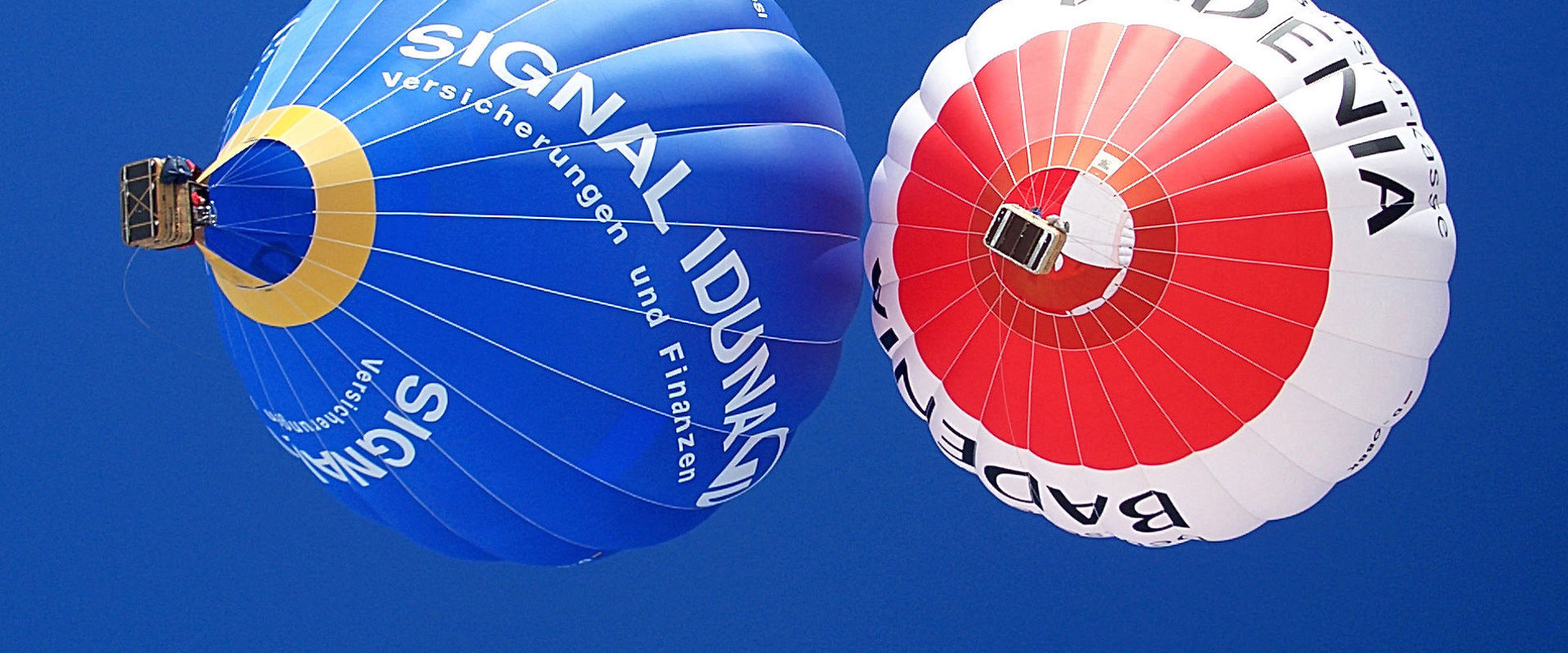 Hot air balloon tours in South Tyrol. Two hot air balloons colour the blue sky of South Tyrol.