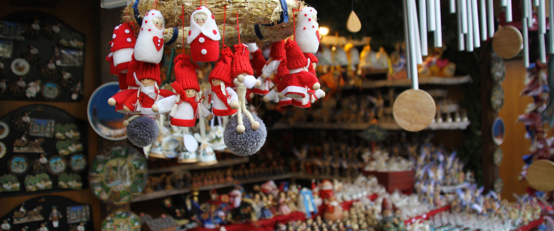 Christmas market stall with wreaths, chimes and tree decorations.