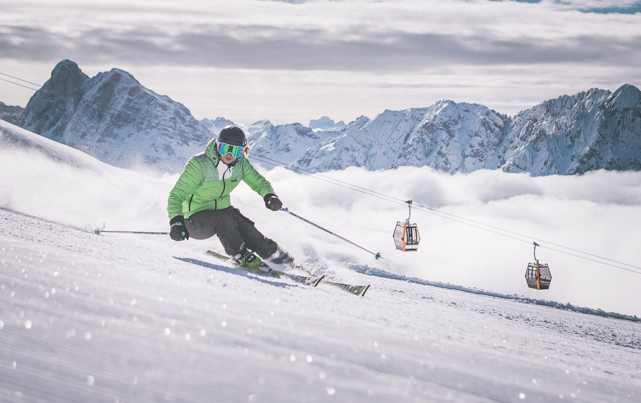 Skier on the slopes of Mt. Plsoe with cable car and Dolomites
