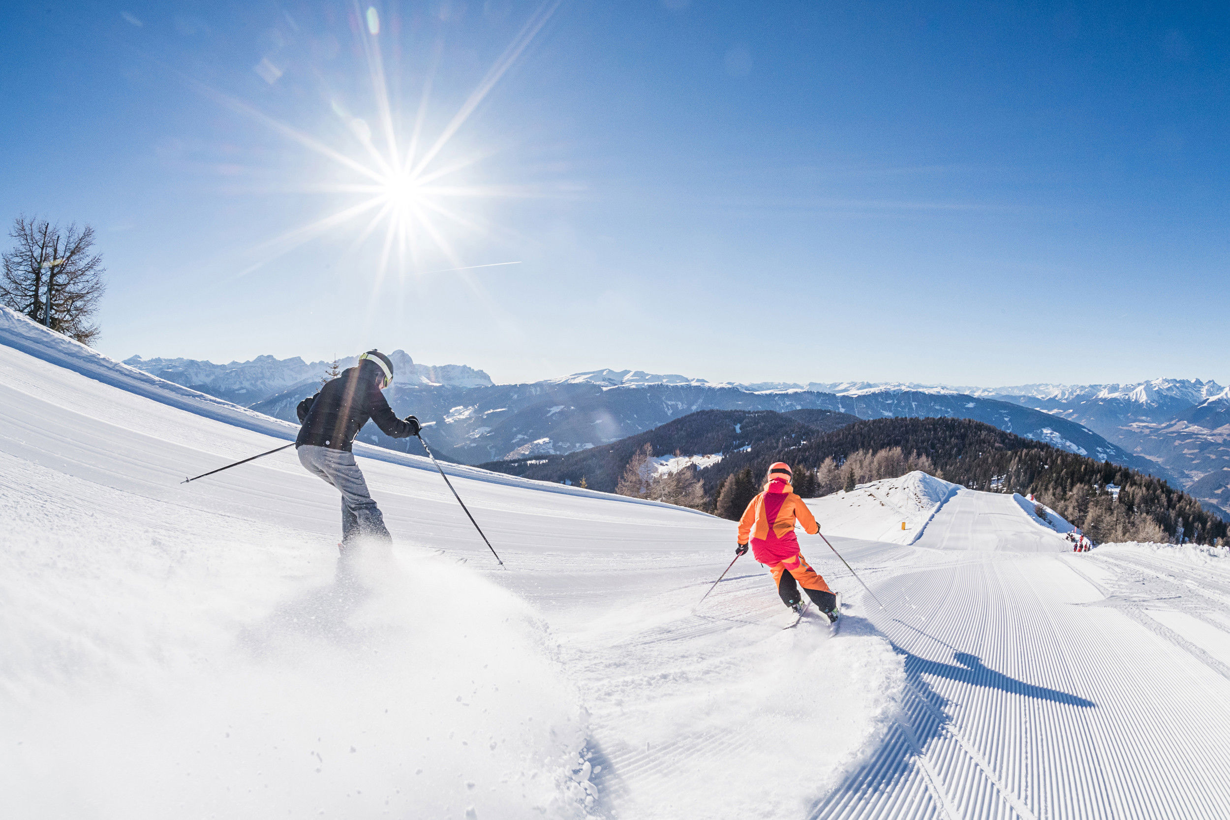 2 skiers ride down the freshly prepared slope.