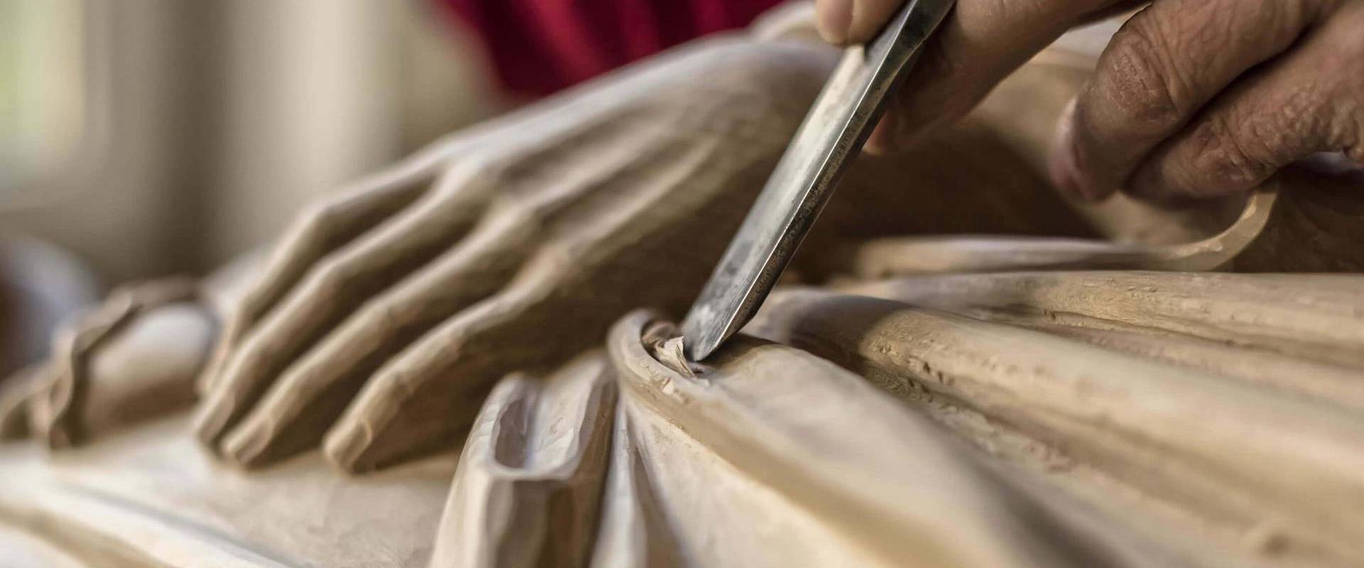 Man carving a wooden statue.