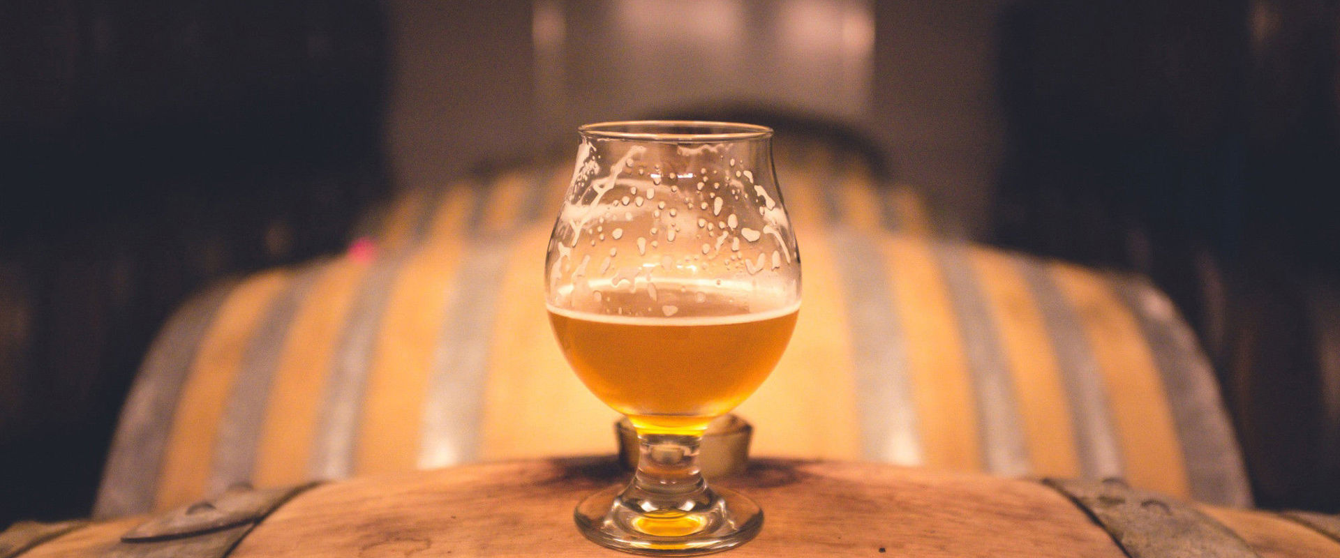 Beer kegs with half a glass of beer on top.