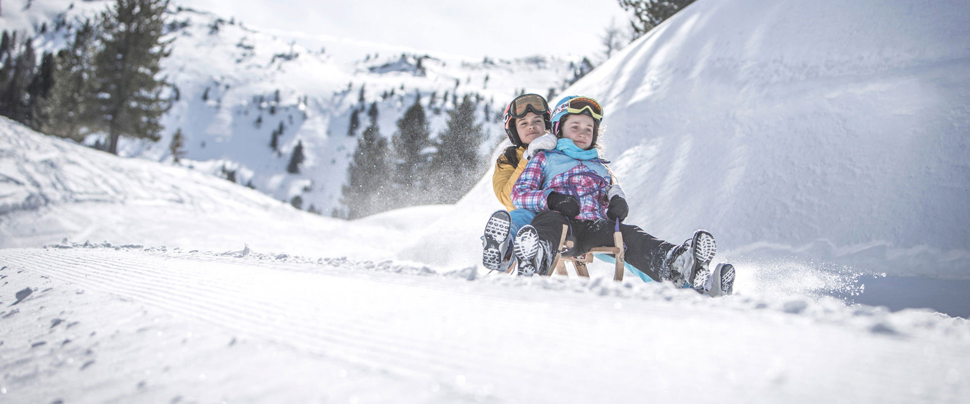 Speikboden toboggan run Mother and daughter ride down the slope on a toboggan.