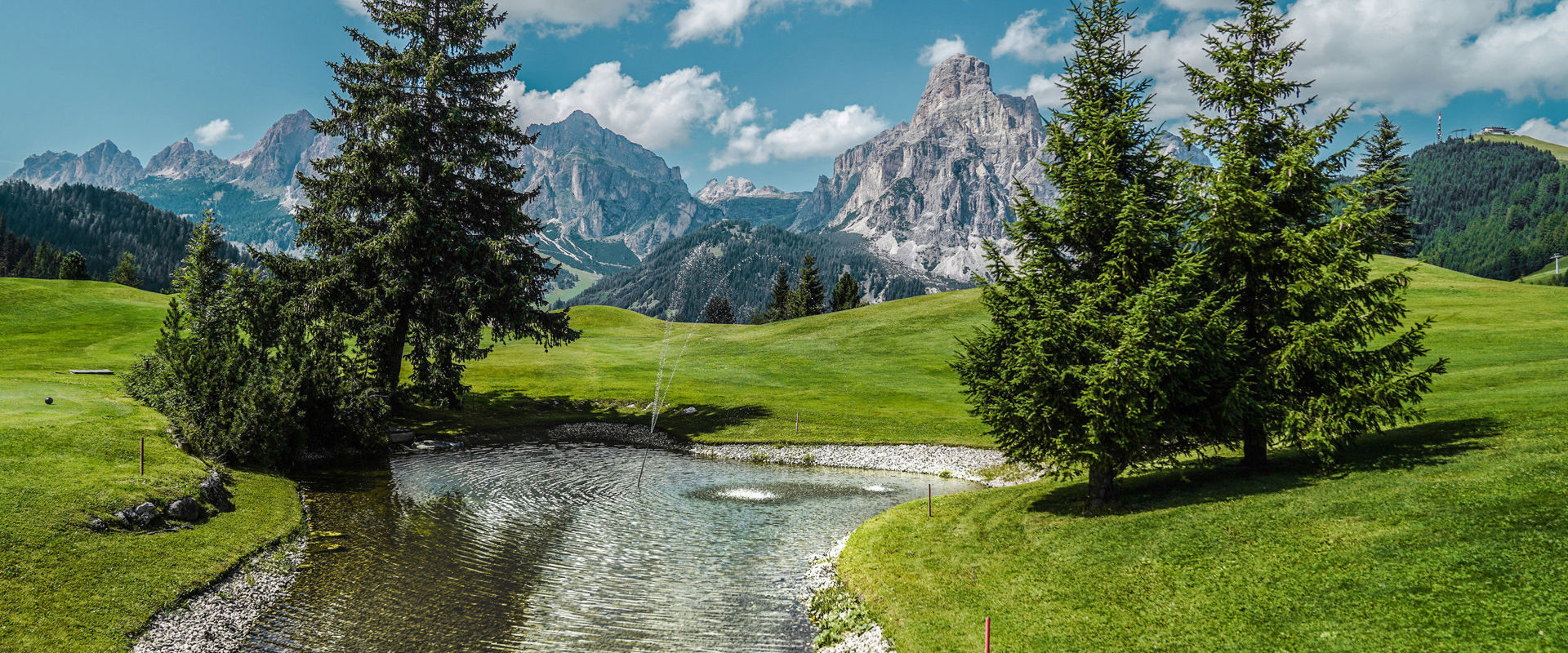 View of the breathtaking peaks of the Dolomites from a water reservoir on the golf course.