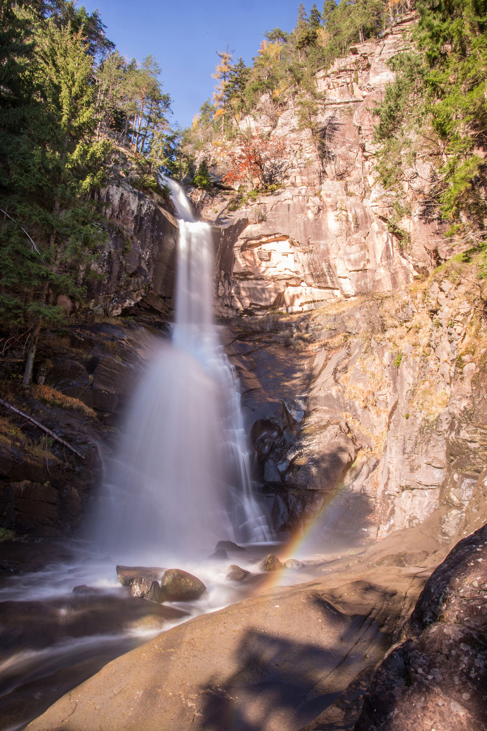 The waterfall roars down the steep rock face.