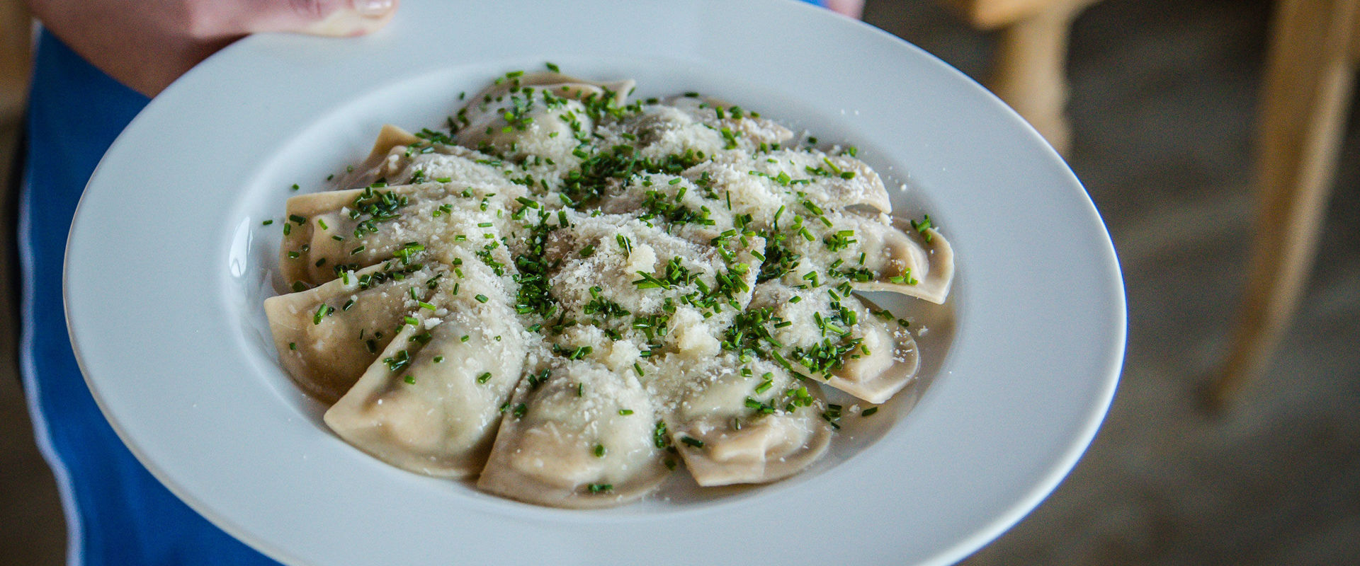 Waitress brings plate with Schlutzkrapfen.