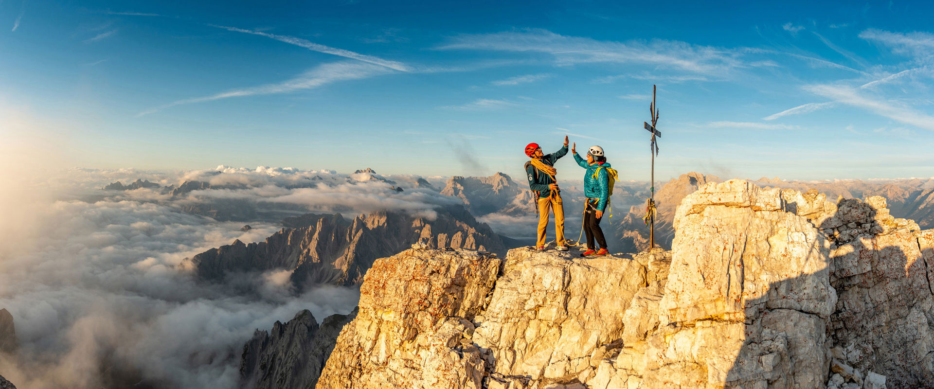 Alpine school Three Peaks in Sexten Two climbers celebrate their arrival at the summit cross.