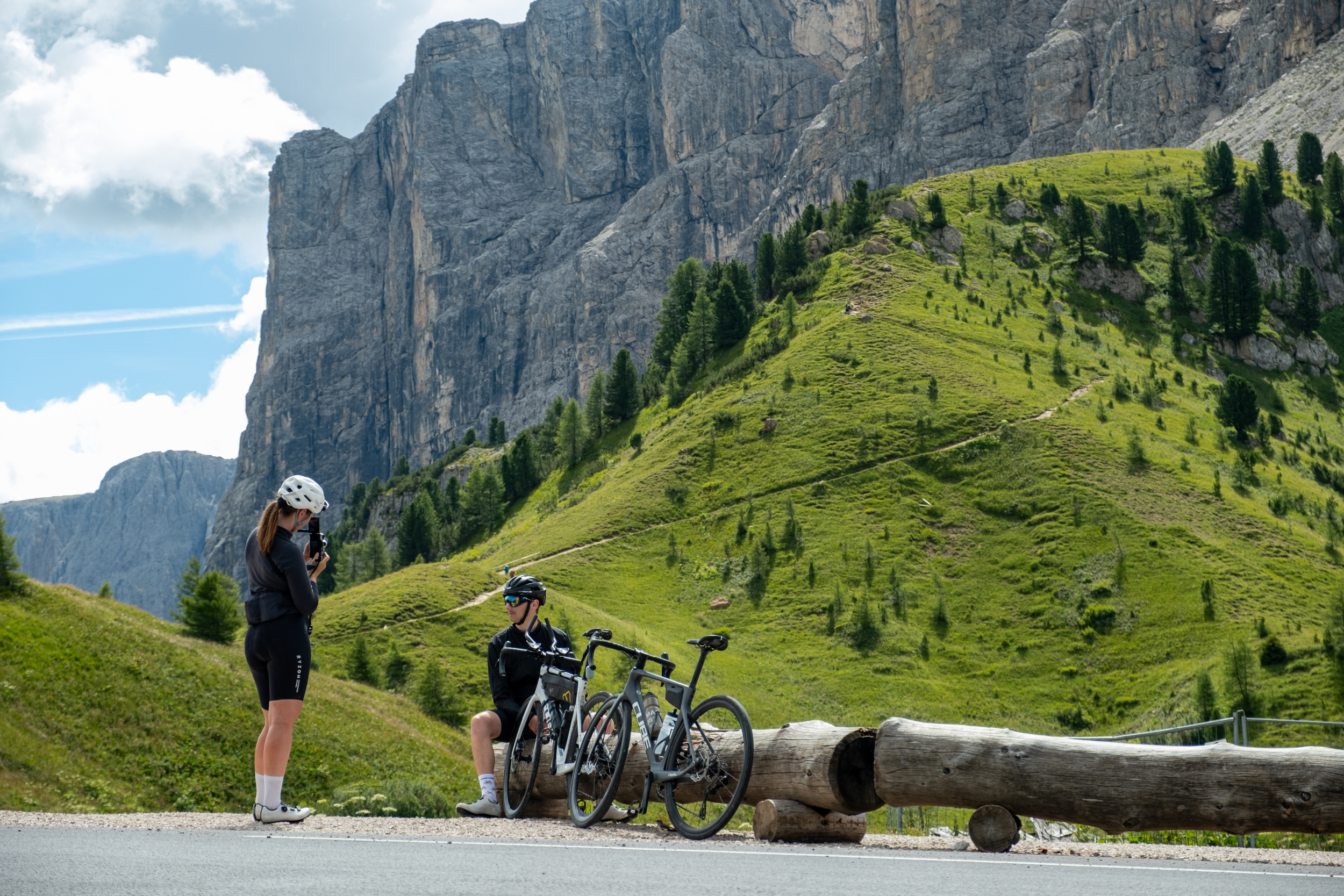 Road cyclists taking a break on a mountain pass road in the Dolomites