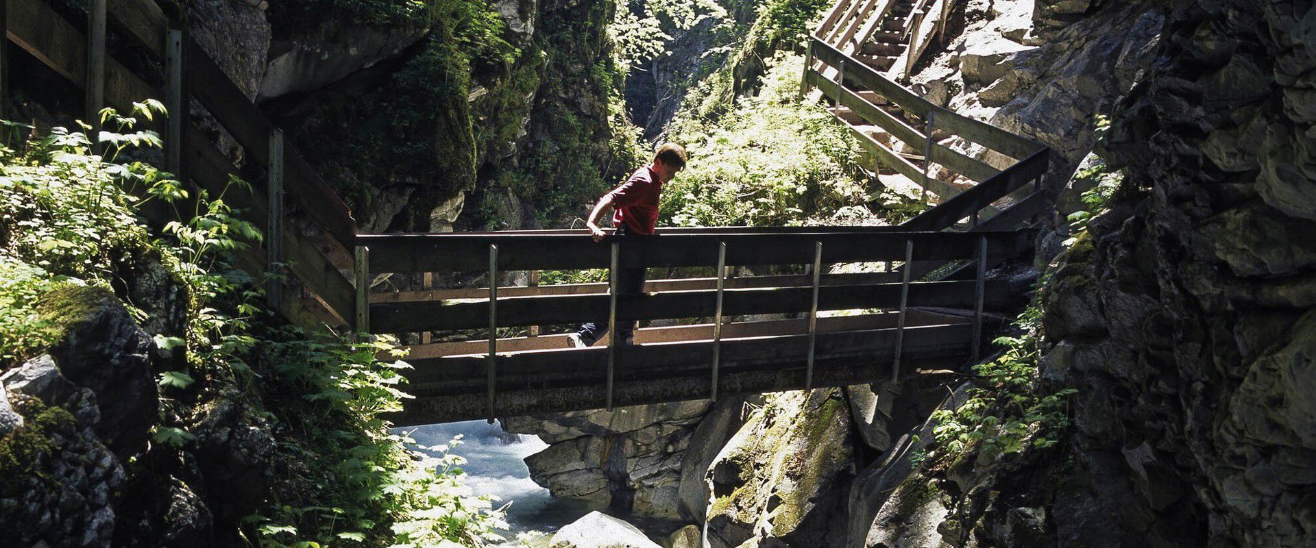 Gilfenklamm gorge Man walking on a bridge over the gorge.