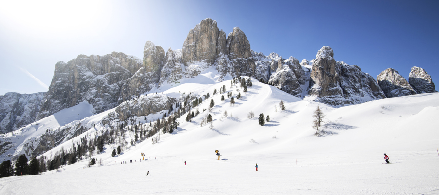 Skiing in bright sunshine with Dolomite peaks